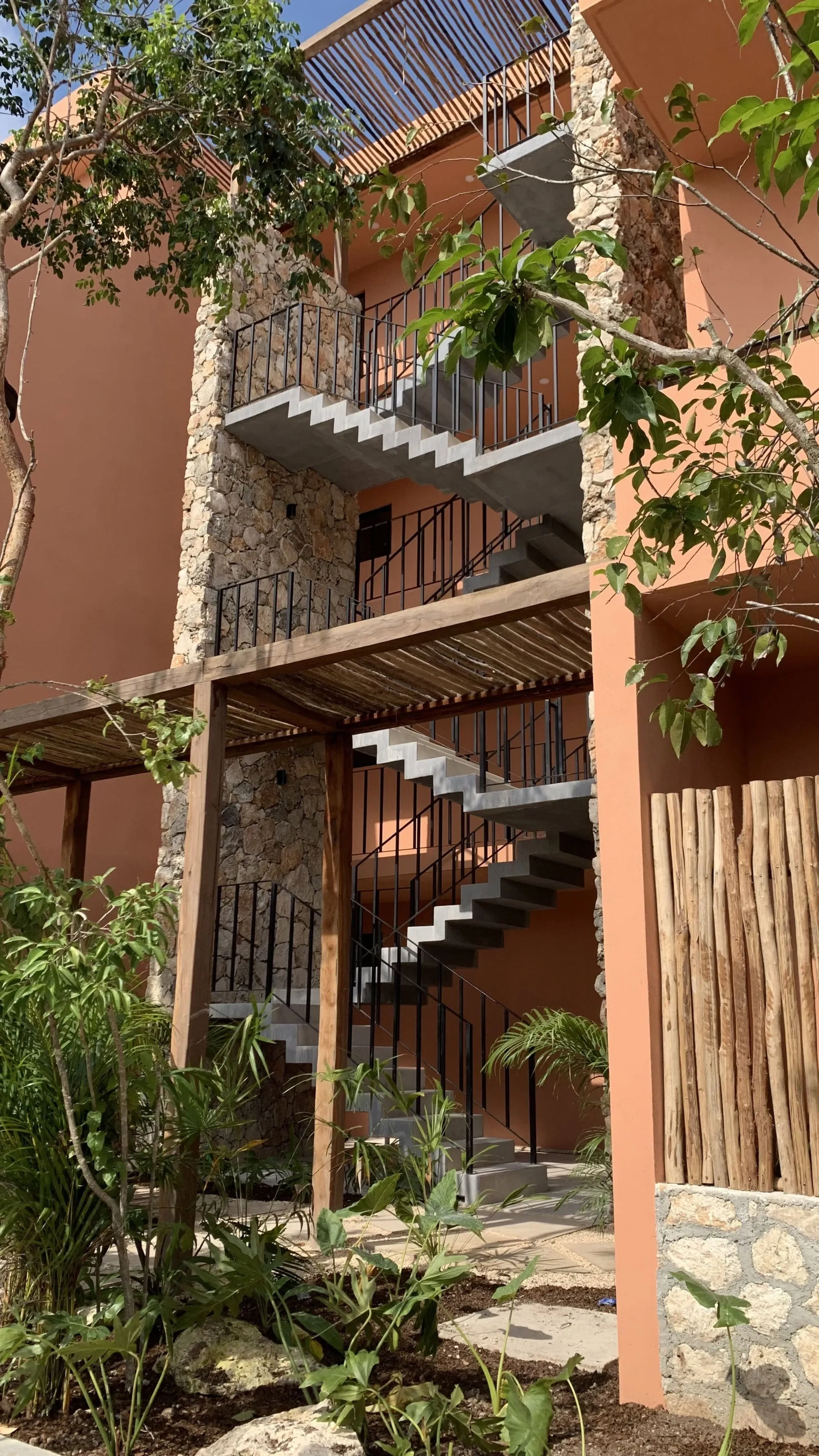 Fachada de hotel boutique con vegetación
